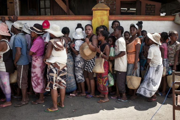 People queue up to buy cheap cooking oil and rice at a shop run by supporters of Madagascar presidential candidate Andry Rajoelina