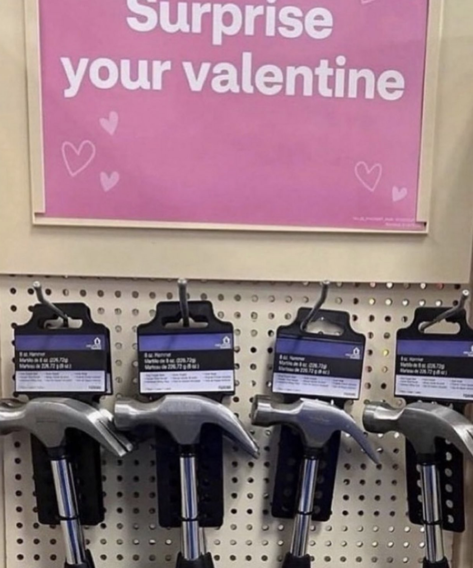 A "Surprise your valentine" sign with hammers on a shelf