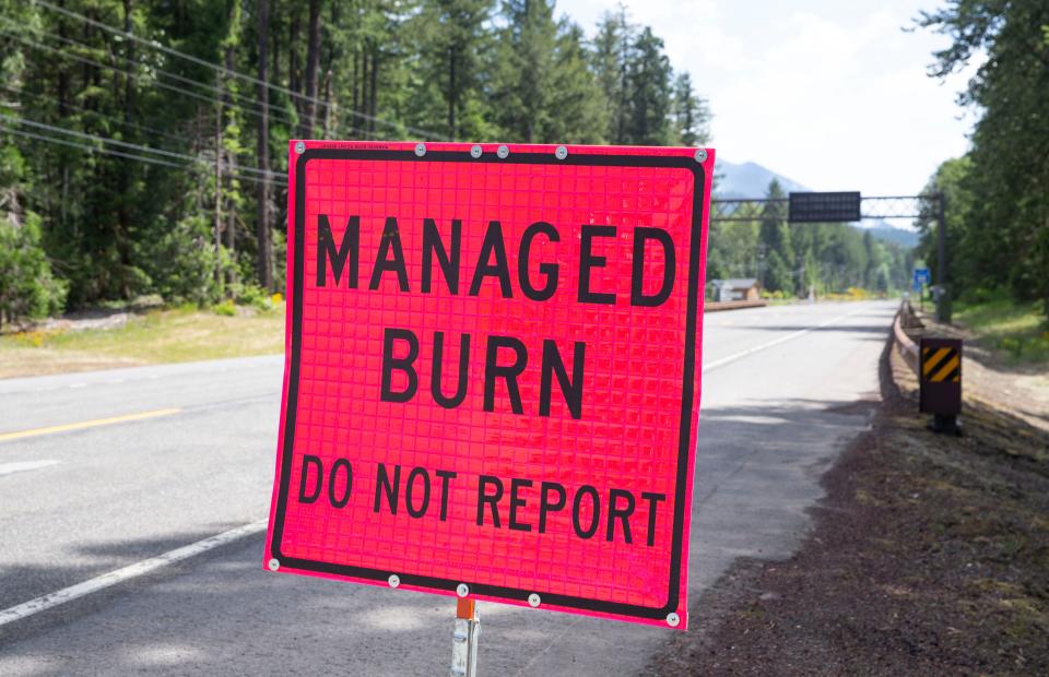 A sign warns drivers on Highway 126 about a fire on the hillside northeast of McKenzie Bridge on Wednesday. The fire began as a prescribed burn but broke out Tuesday afternoon.