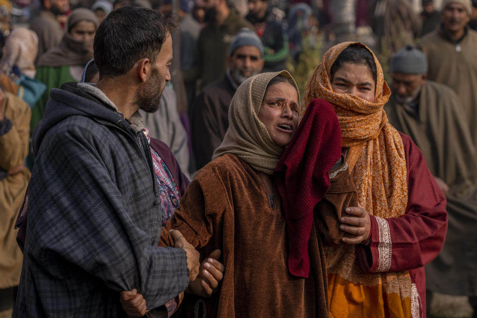 Unidentified Kashmiri villagers grieve near a damaged residential house where suspected rebels were taking refuge, after a gunfight in Kulgam south of Srinagar, Indian controlled Kashmir, Friday, Nov. 17, 2023. Police in Indian-controlled Kashmir said government forces killed five suspected militants in a gunbattle on Thursday. (AP Photo/Dar Yasin)