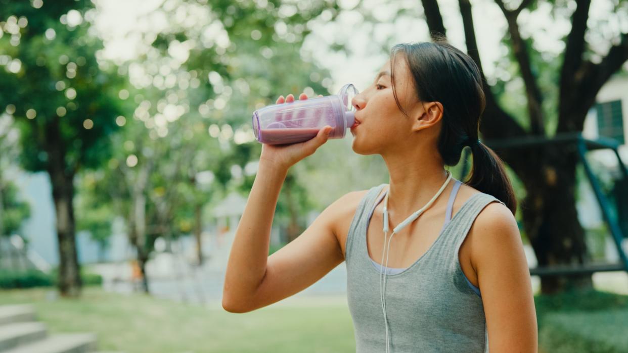  Woman drinking a protein drink. 