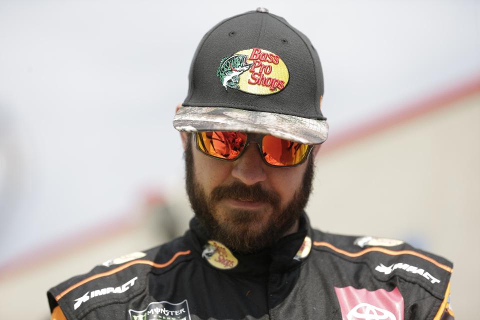 Martin Truex Jr. pauses to sign an autograph for a fan during practice for Sunday's NASCAR Cup Series auto race at Charlotte Motor Speedway in Concord, N.C., Saturday, Sept. 28, 2019. (AP Photo/Gerry Broome)