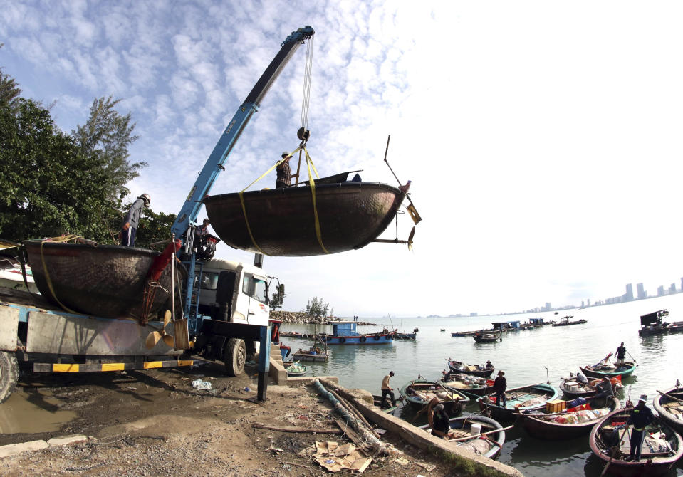 People move fishing boats to save place ahead of Typhoon Molave in Danang, Vietnam on Monday, Oct. 26, 2020. National agency forecasts the typhoon to hit Vietnam on Wednesday morning in the central region where 1.3 people could face evacuation. (Tran Le Lam/VNA via AP)