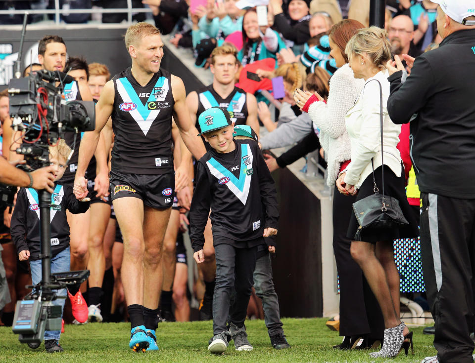 Kane Cornes, pictured here running onto the field for his 300th and final game for Port Adelaide in 2015.