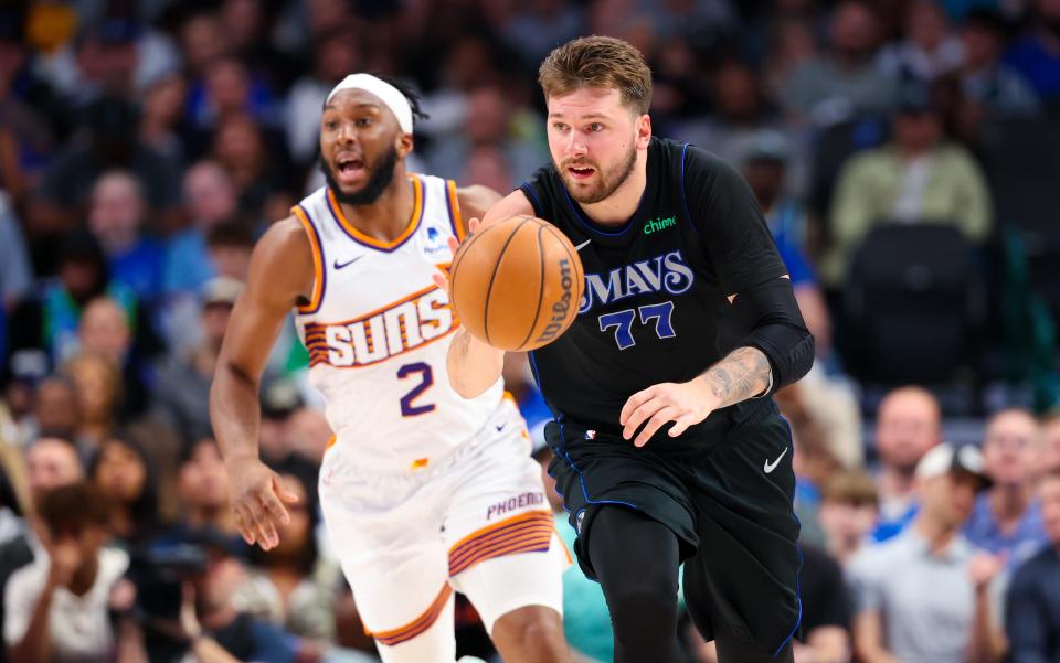 Dallas Mavericks guard Luka Doncic (77) dribbles past Phoenix Suns forward Josh Okogie (2) during the first half at American Airlines Center.