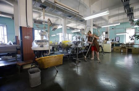 Employee Ana Ostoni of clothing retailer Arena Modna Kuca sweeps the floor at the company's factory in the Adriatic town of Pula July 1, 2014. REUTERS/Antonio Bronic