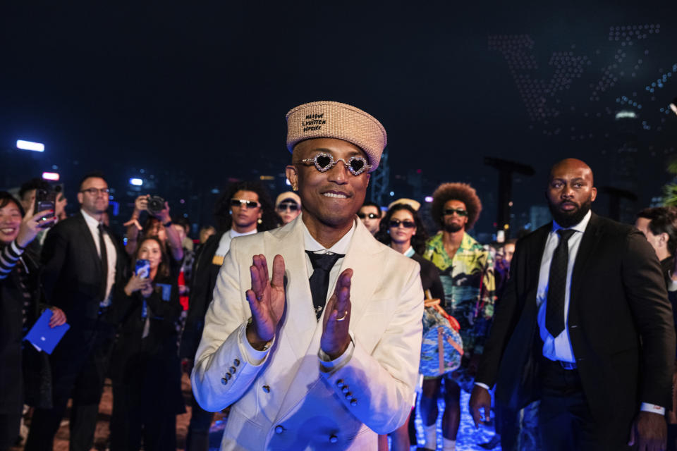 Designer Pharrell Williams applauds at the conclusion of the Louis Vuitton Men's Pre-Fall 2024 Fashion Show, presented in Hong Kong, Thursday, Nov. 30, 2023. (AP Photo/Louise Delmotte)