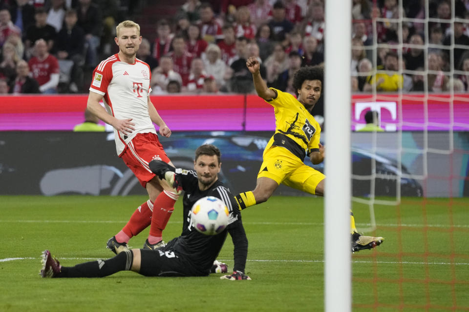 Dortmund's Karim Adeyemi, right, scores his side's opening goal during the German Bundesliga soccer match between FC Bayern Munich and Borussia Dortmund at the Allianz Arena stadium, in Munich, Germany, Saturday, March 30, 2024. (AP Photo/Matthias Schrader)