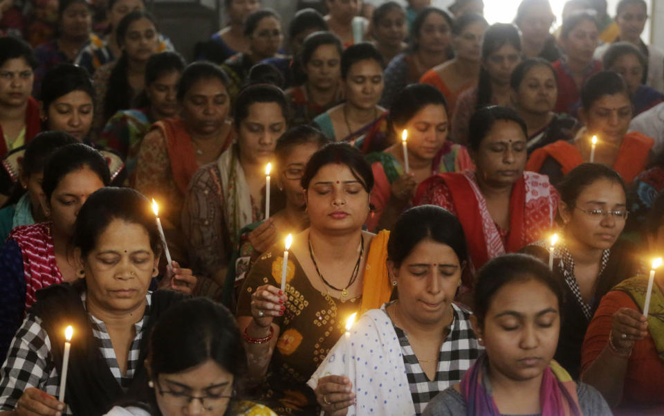 Indian staff at a school pray for the victims of Sunday's blasts in Sri Lanka, in Ahmadabad, India, Monday, April 22, 2019. Easter Sunday bombings that ripped through churches and luxury hotels in Sri Lanka killed more than 200 people. (AP Photo/Ajit Solanki)