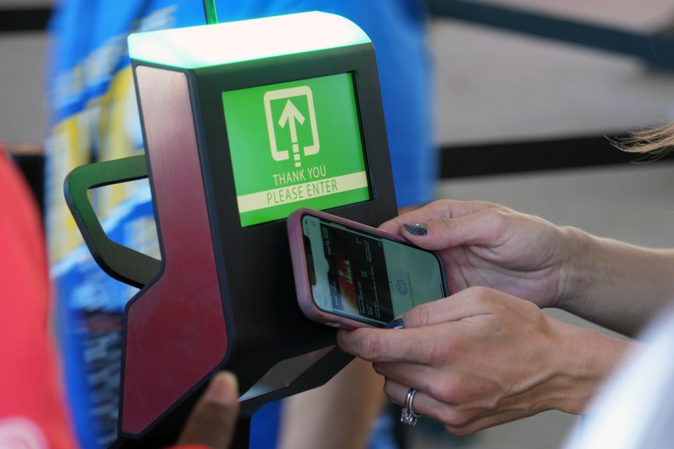 Fans use a digital phone pass ticket scanner to enter the stadium before the game between the Los Angeles Rams and the Cincinnati Bengals in Super Bowl LVI at SoFi Stadium.