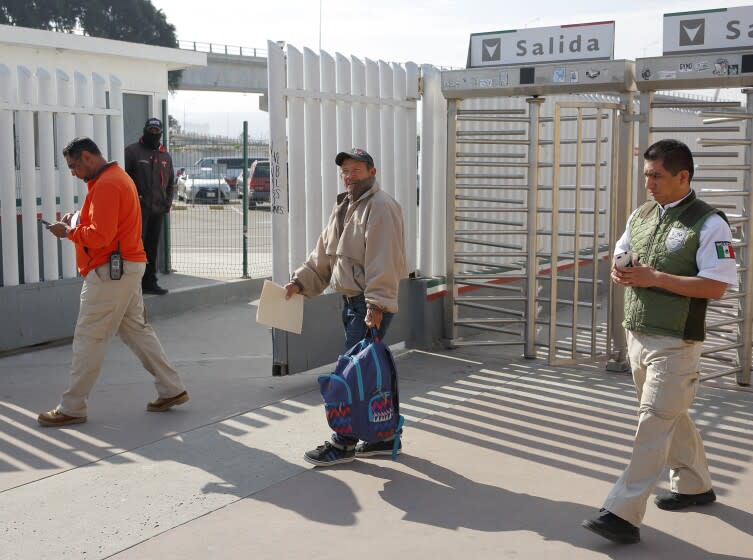 FILE - In this Jan. 29, 2019, file photo, migrant Carlos Catarldo Gomez, of Honduras, center, is escorted by Mexican officials after leaving the U.S., the first person returned to Mexico to wait for his asylum trial date as part of a new program "Remain In Mexico" policy in Tijuana, Mexico. The Supreme Court has ordered the reinstatement of the policy, saying that the Biden administration likely violated federal law by trying to end the Trump-era program that forces people to wait in Mexico while seeking asylum in the U.S. The decision immediately raised questions about what comes next for the future of the policy, also known as the Migrant Protection Protocols. (AP Photo/Gregory Bull, File)