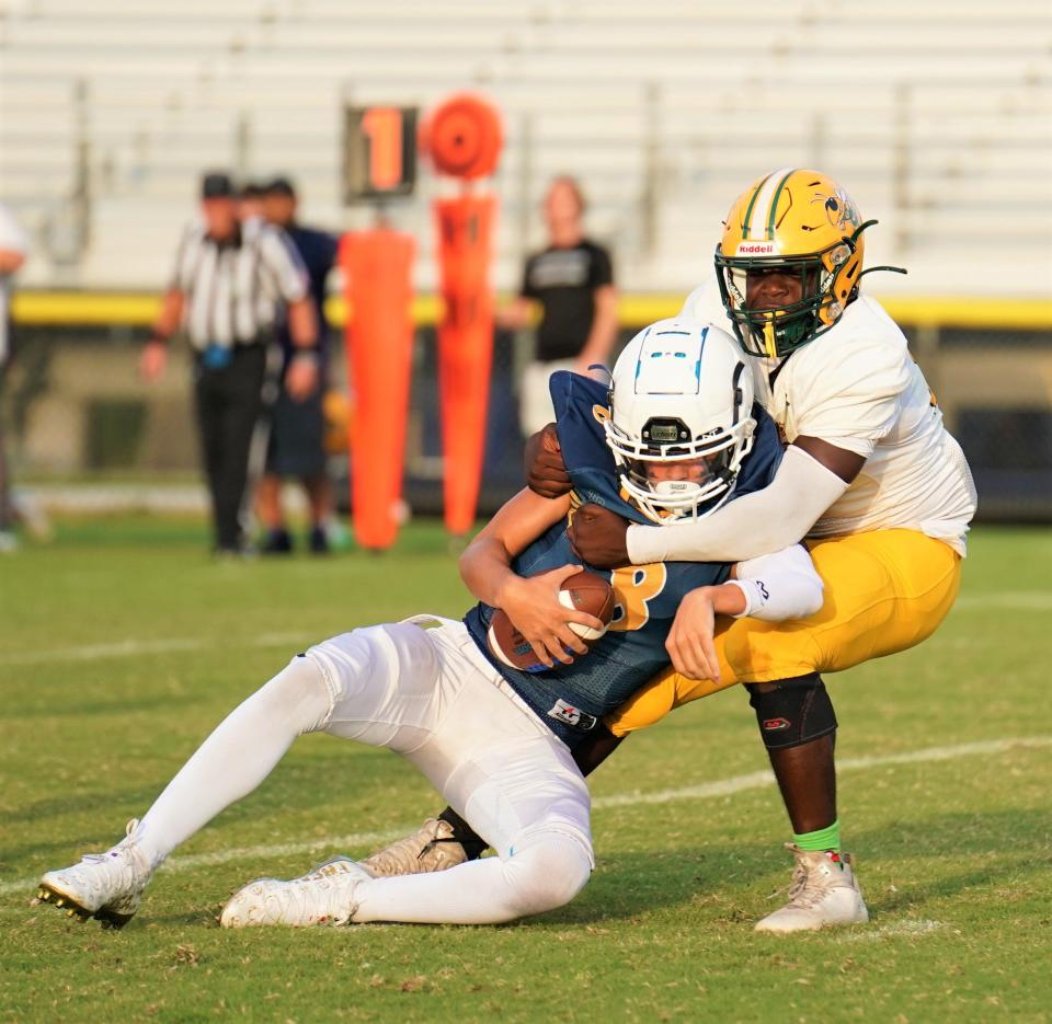 Yulee's defense makes a sack on Tradition Prep quarterback Mason Brown (8) during a high school football game on September 23, 2023. [Bryan Cooney/TC Palm]