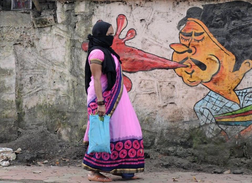 Une femme passe devant un graffiti à Mumbai.  La corporation municipale sensibilise aux dangers de cracher dans les lieux publics à travers des graffitis.