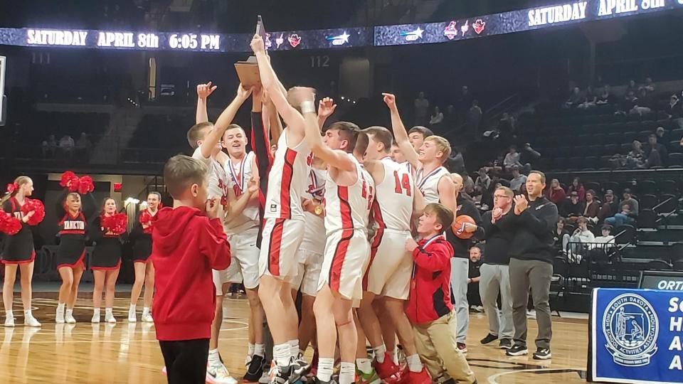 The Yankton boys basketball team hoists its trophey after claiming the Class AA boys state championship title Saturday, March 19, 2023, in Rapid City.