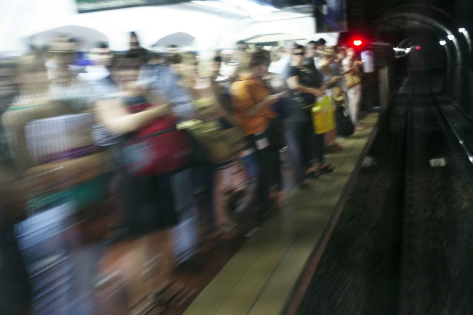 In this Feb. 12, 2014 photo, people commute in the subway in Buenos Aires, Argentina. Argentines have suffered through a tough summer, with tropical rain that provided no relief from the heat and humidity, people having to throw out rotten food because of rolling power blackouts and soaring oil and gas prices, all amid rising inflation that is making it ever harder to reach the end of the month. The strain is evident on the faces of subway riders and others making their way home in Buenos Aires, where signs of poverty and decay are ubiquitous just beyond the glamorous streets where tourists go. (AP Photo/Rodrigo Abd)