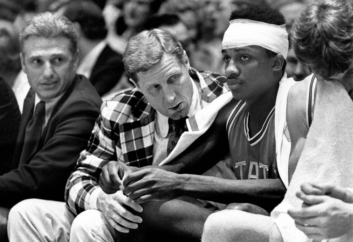 NC State coach Norm Sloan talks to an injured David Thompson after he returned to the game from the hospital in 1974.  Thompson took a terrible fall against Pittsburgh, but returned for the Wolfpack victory.