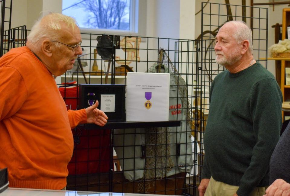 Area Heritage Foundation President James Rusincovitch, left, talks with Ottawa County Museum Board Member David Barth about the upcoming Purple Heart exhibit at the museum.