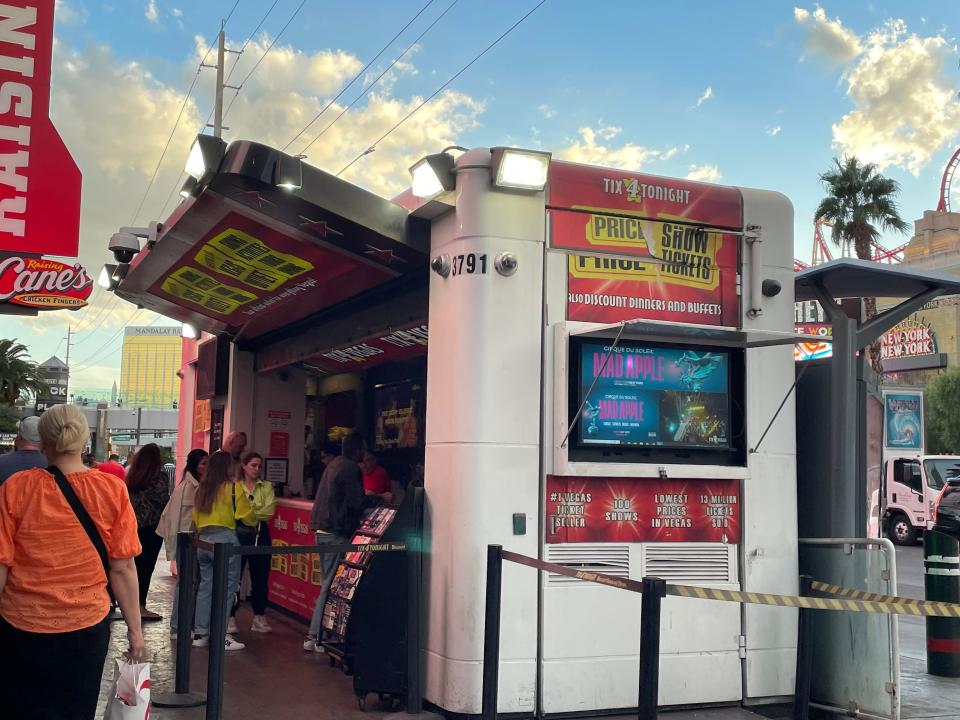 half-price ticket booth on the street in las vegas next to a raising canes