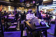 Attendees sample one of the many virtual reality rides during the International Association of Amusement Parks and Attractions convention Tuesday, Nov. 19, 2019, in Orlando, Fla. (AP Photo/John Raoux)