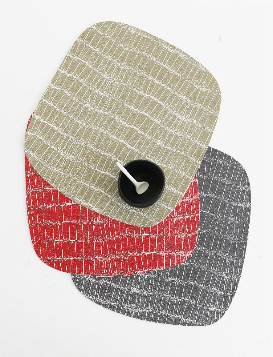 This undated publicity photo provided by Chilewich shows Mod Croc retro shape placements in tan, red and black. The Mod Croc embossed graphic is part of Sandy Chilewich’s manmade animal skin collection of easy to clean placemats (www.chilewich.com). (AP Photo/Chilewich, Victor Schrager Photography)