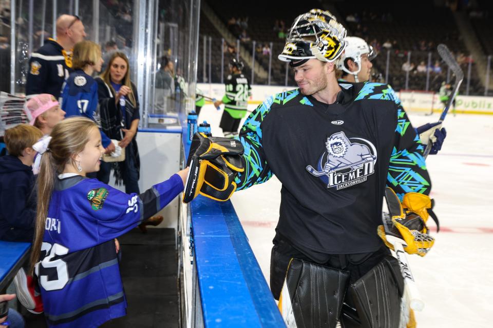 Jacksonville Icemen goaltender Matt Vernon greets a young fan at the bench area before a November game against the Savannah Ghost Pirates. [Gary Lloyd McCullough/For the Jacksonville Icemen]