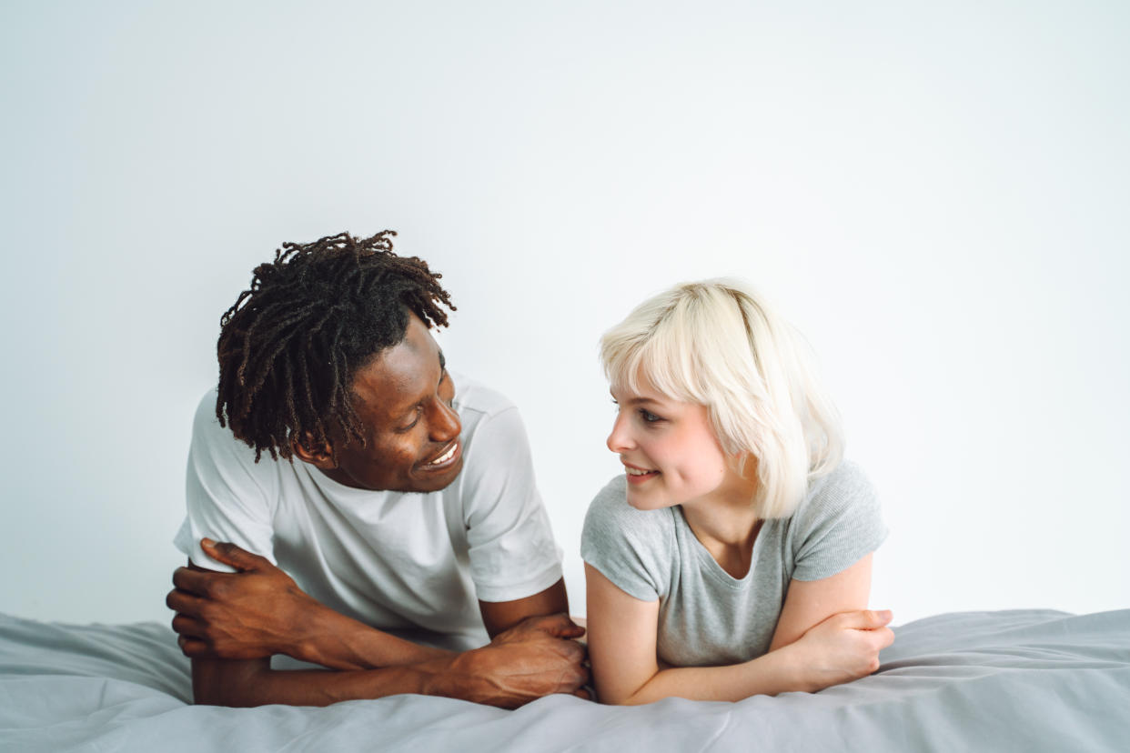 man and woman on bed talking, representing signs of a narcissist hard to spot