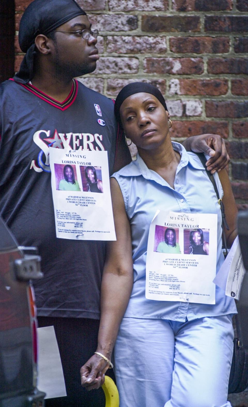 Two people wear posters of a missing woman as they seek information following the attack on the World Trade Centre (EPA)