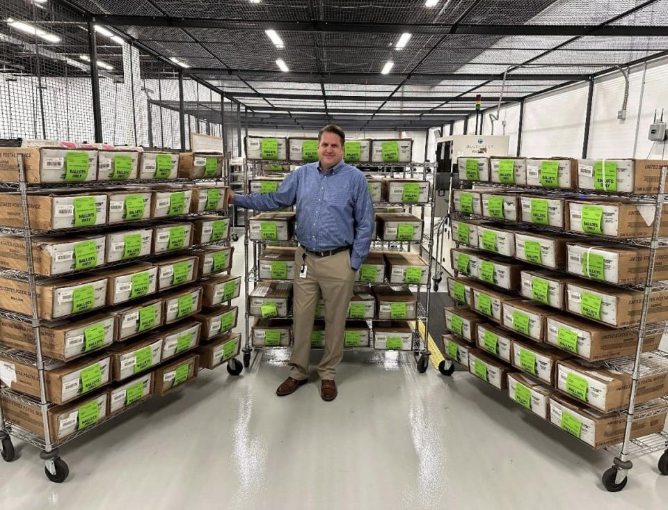 Brevard County Supervisor of Elections Tim Bobanic stands in front of pallets of vote-by-mail ballots before they were mailed out to voters in advance of the March 19 Republican presidential preference primary.