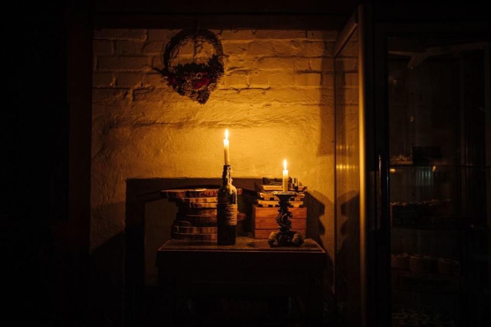 Candles light a restaurant during a power cut in downtown Kyiv on December 6, 2022, amid the Russian invasion of Ukraine. - With temperatures dipping below zero, repeated Russian attacks have left Ukraine's energy grid teetering on the brink of collapse and have disrupted power and water supplies to millions over recent weeks.<span class="copyright">Dimitar DILKOFF- AFP</span>