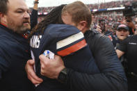 Virginia head coach Bronco Mendenhall, right, buries his head in the shoulder of Virginia quarterback Bryce Perkins (3) as he and his team celebrate beating Virginia Tech after an NCAA college football game between Virginia Tech and Virginia in Charlottesville, Va., Friday, Nov. 29, 2019. Virginia defeated Virginia Tech 39-30 for the first time in 15 years. (AP Photo/Steve Helber)