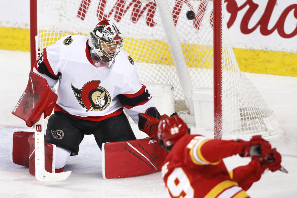 Ottawa Senators goalie Filip Gustavsson, left, gives up a goal to Calgary Flames' Dillon Dube during the third period of an NHL hockey game Sunday, May 9, 2021, in Calgary, Alberta. (Larry MacDougal/The Canadian Press via AP)