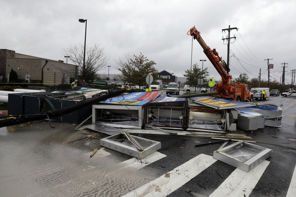 Crews work to remove a damaged sign in the wake of superstorm Sandy, Tuesday, Oct. 30, 2012, in Philadelphia. Millions of people from Maine to the Carolinas awoke Tuesday without power, and an eerily quiet New York City was all but closed off by car, train and air as superstorm Sandy steamed inland, still delivering punishing wind and rain.(AP Photo/Matt Slocum)