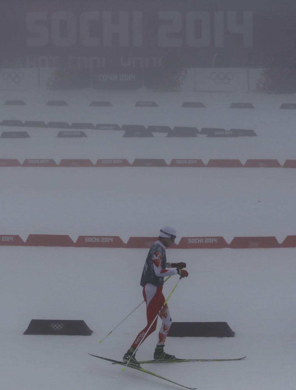 Unidentified athletes ski through the fog as the men's biathlon 15K mass start race has been postponed due to the lack of visibility at the 2014 Winter Olympics, Sunday, Feb. 16, 2014, in Krasnaya Polyana, Russia. (AP Photo/Gregorio Borgia)