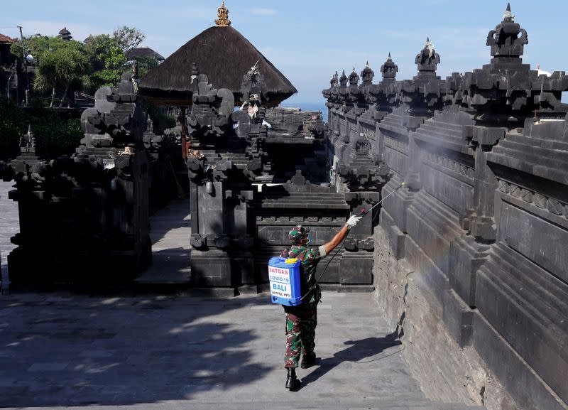 FILE PHOTO: An Indonesian soldier sprays disinfectant to prevent the spread of coronavirus disease (COVID-19) at Tanah Lot temple in Tabanan, Bali