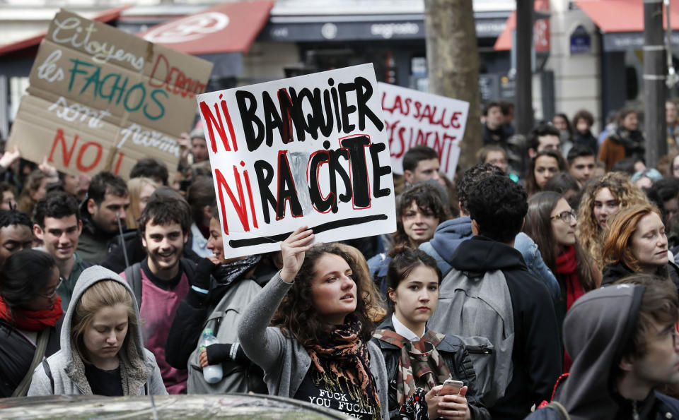 <p>Students hold a placard reading “Neither banker, nor racist” during a demonstration in Paris on April 27, 2017 to protest against the results of the first round of the French presidential election. (Thomas Samson/AFP/Getty Images) </p>