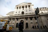 A man wearing a protective face mask, following an outbreak of the coronavirus, walks in front of the Bank of England in London