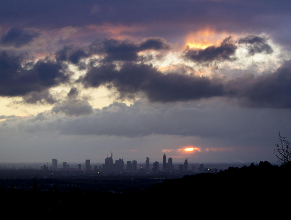 The sun rises between clouds over the banking district of Frankfurt, Germany, Tuesday, Jan. 8, 2019. (AP Photo/Michael Probst)