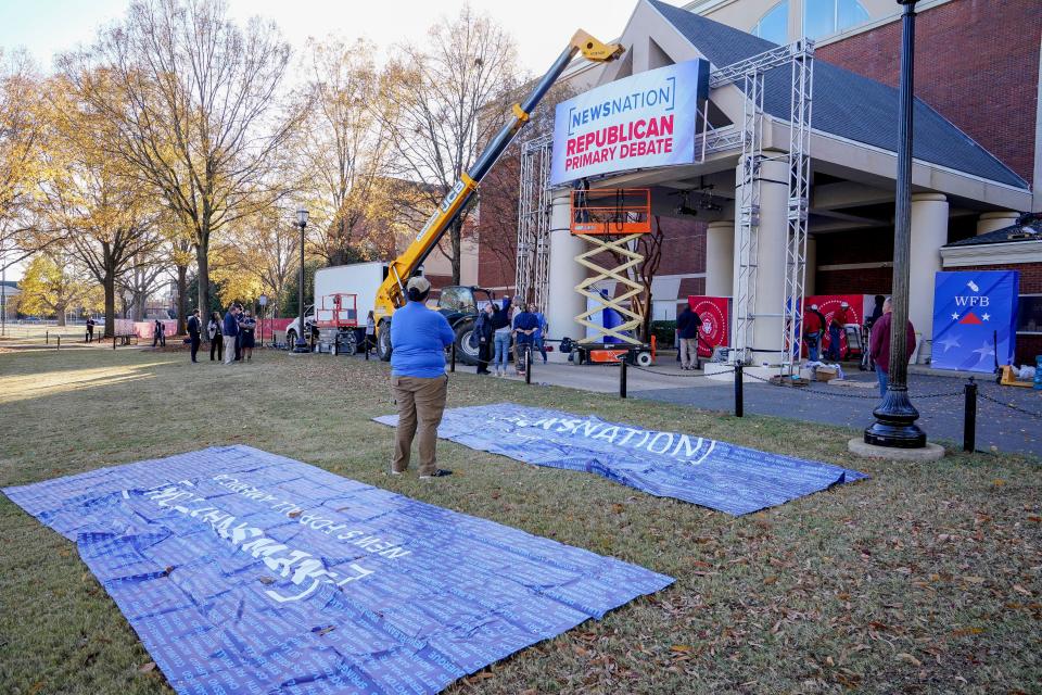 Sign riggers work on the signage for the Republican Primary Debate outside Moody Music Hall on the campus of the University of Alabama in Tuscaloosa Tuesday, Dec. 5, 2023. The debate takes places on Dec. 6.