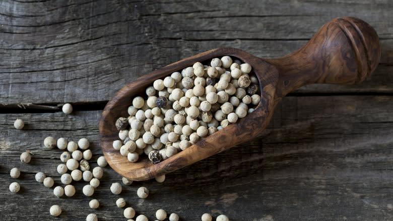 wooden scoop of white peppercorns