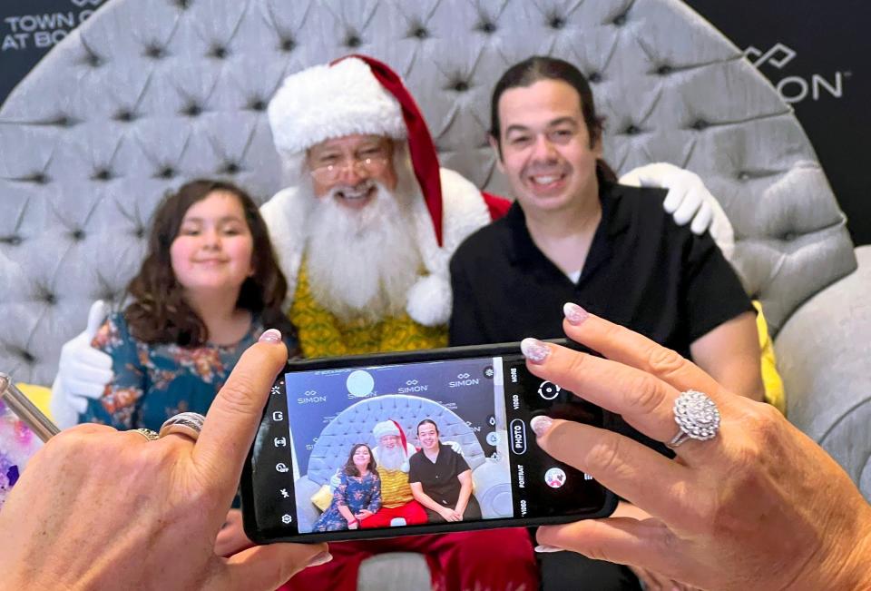 A family poses with Santa as families enjoyed a Christmas dinner courtesy of Boca Helping Hands and Town Center at Boca Raton, where 500 people were served in the mall's food court on Dec. 25.