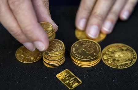 A worker places gold bullion on display at Hatton Garden Metals precious metal dealers in London, Britain July 21, 2015. REUTERS/Neil Hall/Files