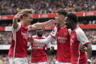 Arsenal's Bukayo Saka, right, celebrates with teammates after scoring his side's opening goal during the English Premier League soccer match between Arsenal and Bournemouth at Emirates Stadium in London, England, Saturday, May 4, 2024. (AP Photo/Frank Augstein)