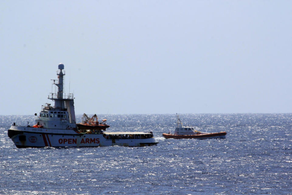 CORRECTS THE DAY OF THE WEEK - The Open Arms Spanish humanitarian boat with 147 migrants, left, is monitored by an Italian Coast guard vessel as it sails off the coasts of the Sicilian island of Lampedusa, southern Italy, Thursday, Aug. 15, 2019. A Spanish aid boat with 147 rescued migrants aboard is anchored off a southern Italian island as Italy's ministers spar over their fate. (Elio Desiderio/ANSA Via AP)