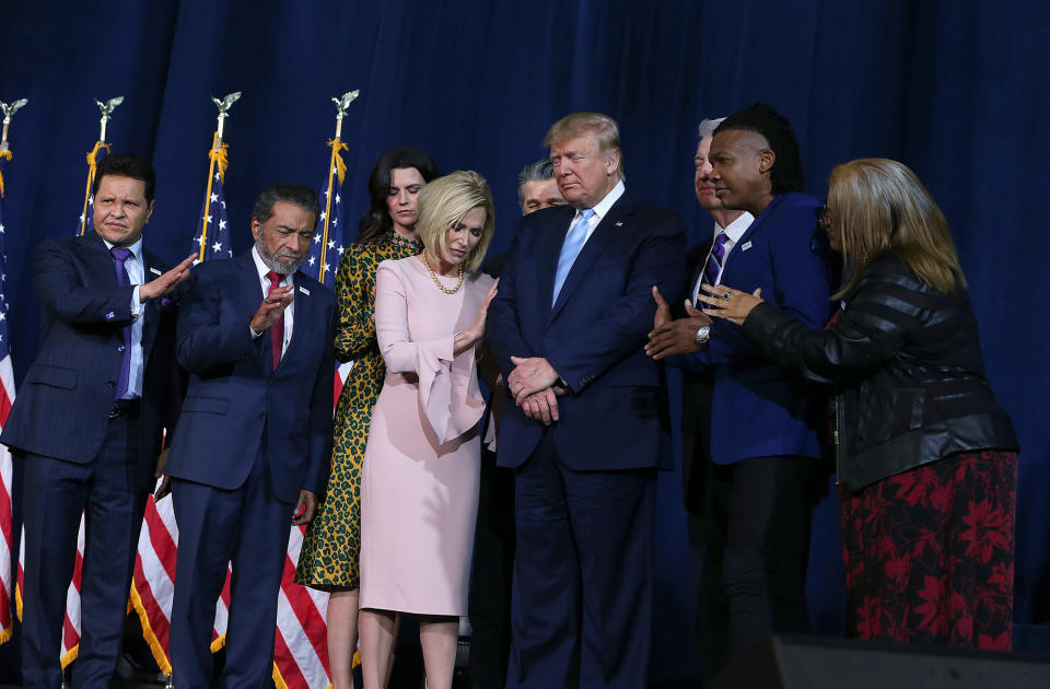 Un grupo de líderes religiosos rezando por el presidente Donald Trump durante un mitin de la campaña 