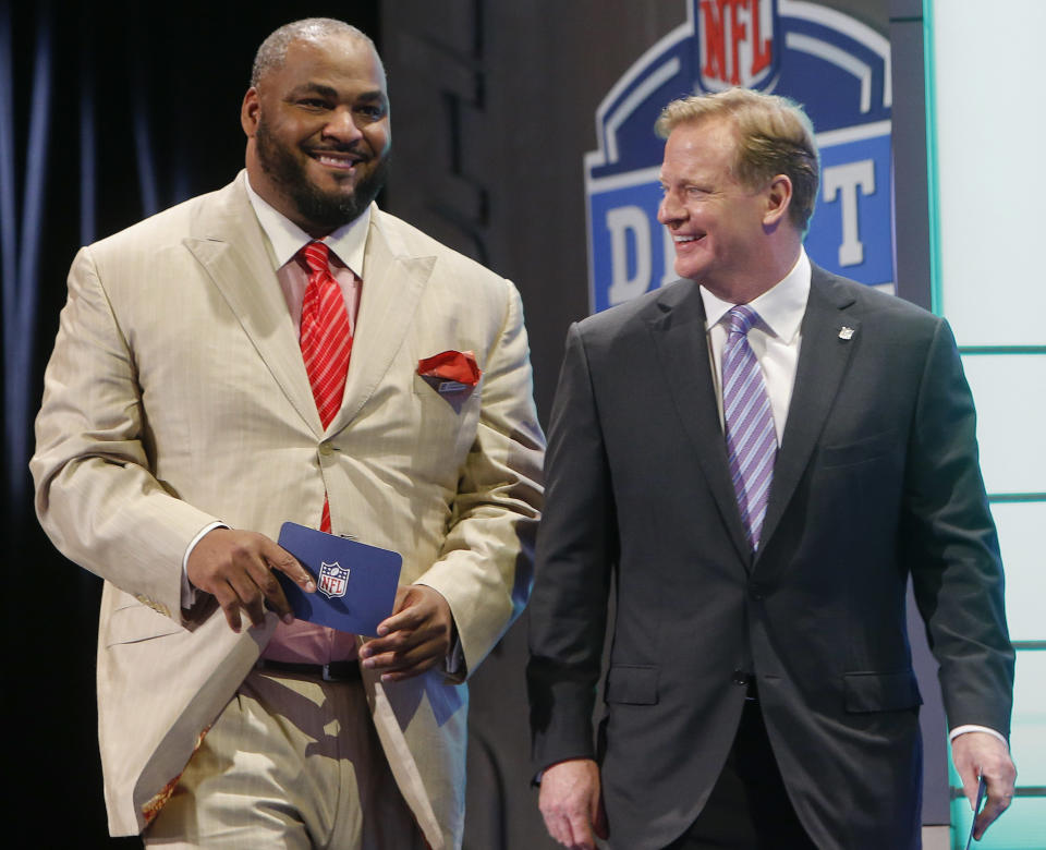 Former Seattle Seahawks linebacker Walter Jones walks out on stage with NFL commissioner Roger Goodell to announce the Seahawks pick for the second round of the 2014 NFL Draft, Friday, May 9, 2014, in New York. (AP Photo/Jason DeCrow)
