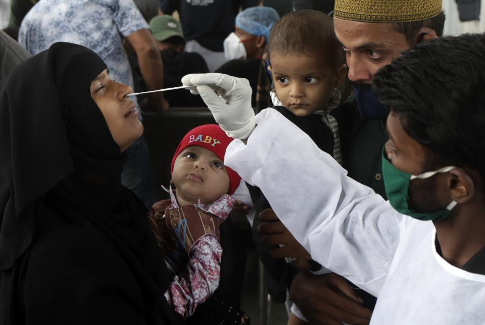 A health worker collects a swab sample for COVID-19 test at a train station in Mumbai, India, Thursday, July 22, 2021. (AP Photo/Rajanish Kakade)