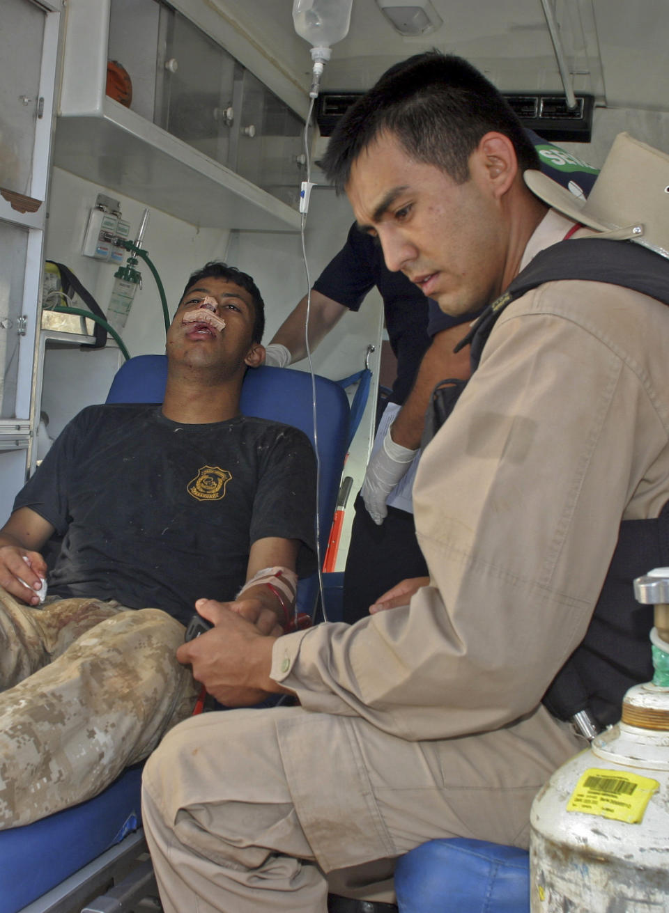 A police officer wounded in a land dispute is transferred via ambulance to a hospital after arriving at the airport in Asuncion, Paraguay, from Curuguaty, Friday, June 15, 2012. Paraguay deployed its army on Friday to resolve the violent land dispute in Curuguaty, a remote northern forest reserve, where 17 people have been killed in gun battles between police and landless farmers when police were trying to evict about 150 farmers from the reserve, which is part of a huge estate owned by a Colorado Party politician opposed to leftist President Fernando Lugo. (AP Photo)