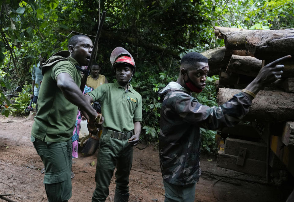 Three rangers argue with illegal loggers near a truck carrying timber inside the Omo Forest Reserve in Nigeria on Wednesday, Aug. 2, 2023. Conservationists and rangers blame the government for not enforcing environmental regulations or adequately replanting trees, impeding Nigeria’s pledge under the Paris climate agreement to maintain places like forests that absorb carbon from the atmosphere. (AP Photo/Sunday Alamba)