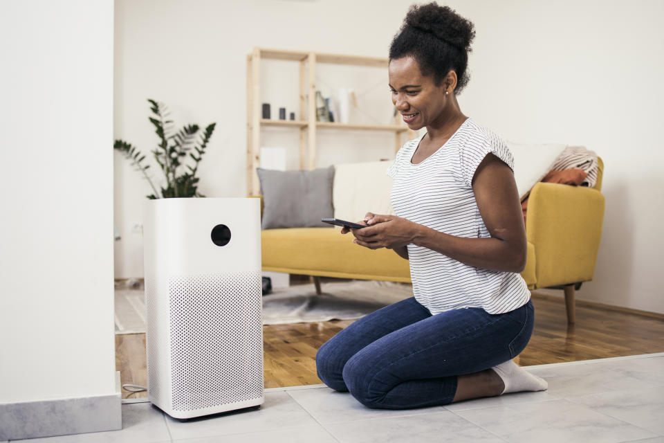 Black woman kneeling in front of a humidifer