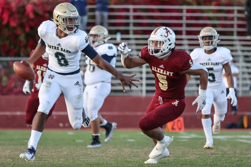 Mission Hills, CA, Friday, March 19, 2021 - Sherman Oaks Notre Dame quarterback Javance Tupouata-johnson is chased by Bishop Alemany linebacker Niuafe Jr Tuihalamaka during second half action at Alemany. (Robert Gauthier/Los Angeles Times)